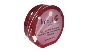 Circle-shaped commemorative marking a new drug application for migraine treatment.